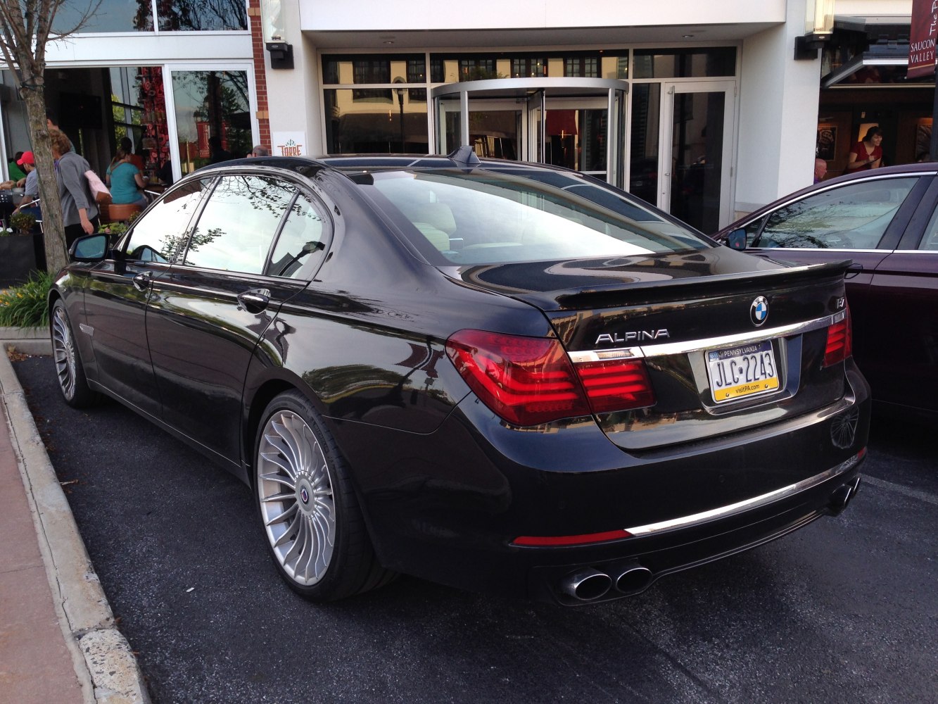 Rear side view featuring quad exhaust and multi-spoke alloy wheels.