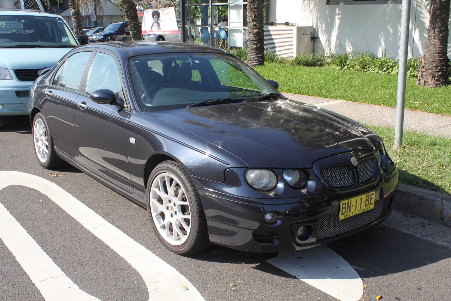 Dual round headlights and sporty alloy wheels on a four-door sedan