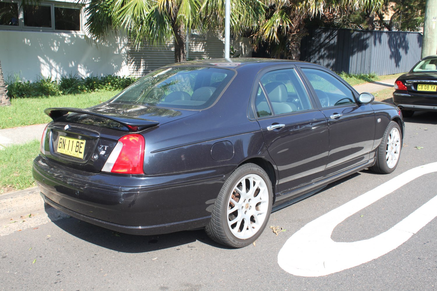 Rear view of sedan with spoiler and alloy wheels