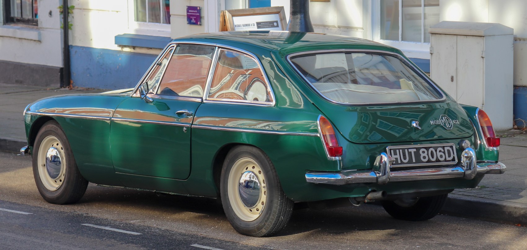 Green vintage two-door sports coupe with hatchback rear and chrome bumpers