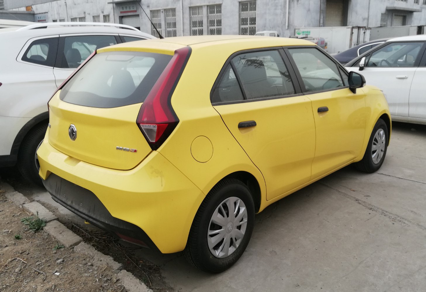 Rear side view of a yellow compact hatchback with angular taillights