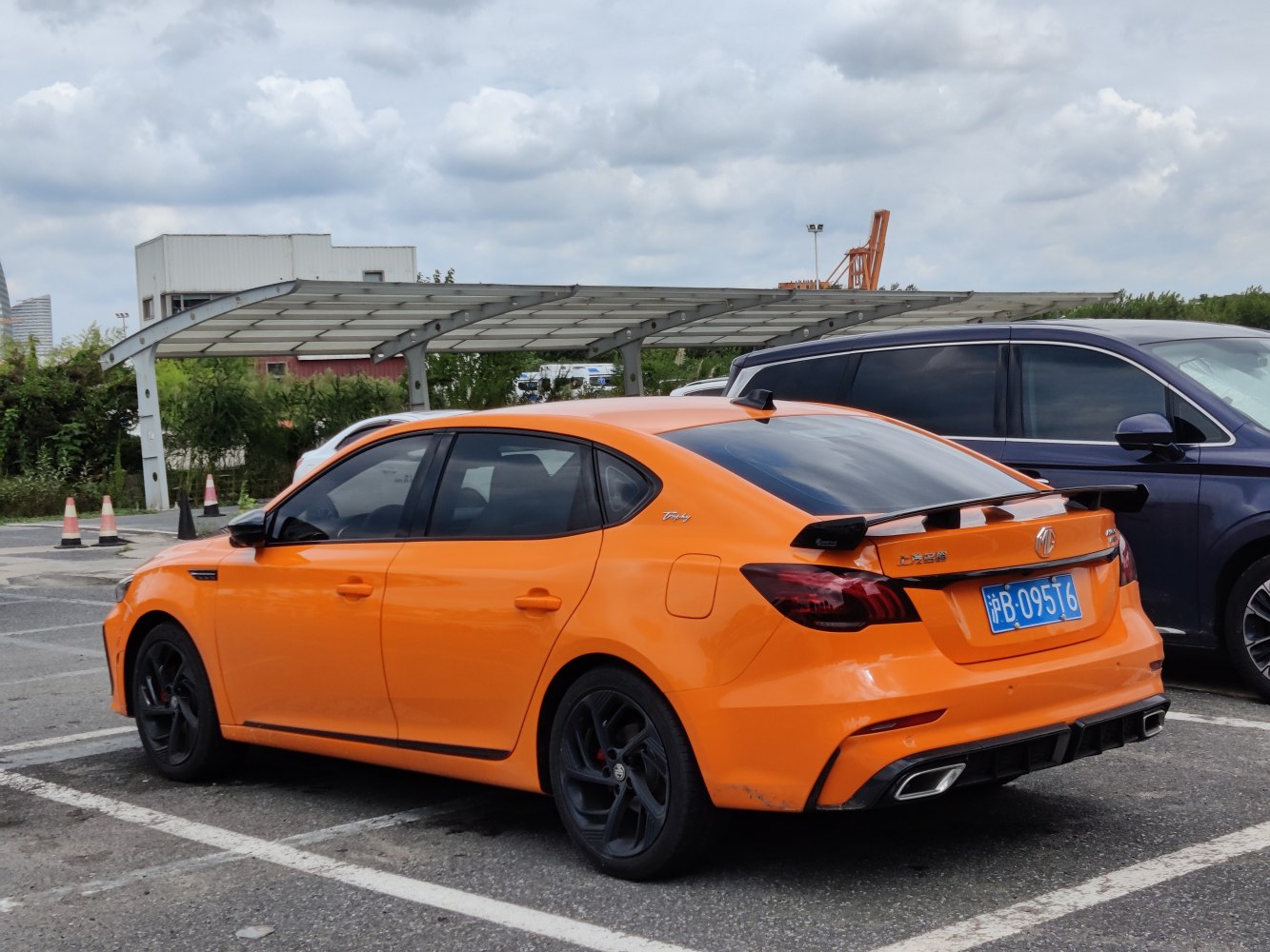 Bright orange sedan with rear spoiler and black alloy wheels