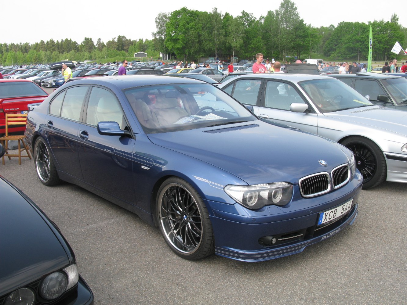Blue sedan with quad headlights and multi-spoke black alloy wheels