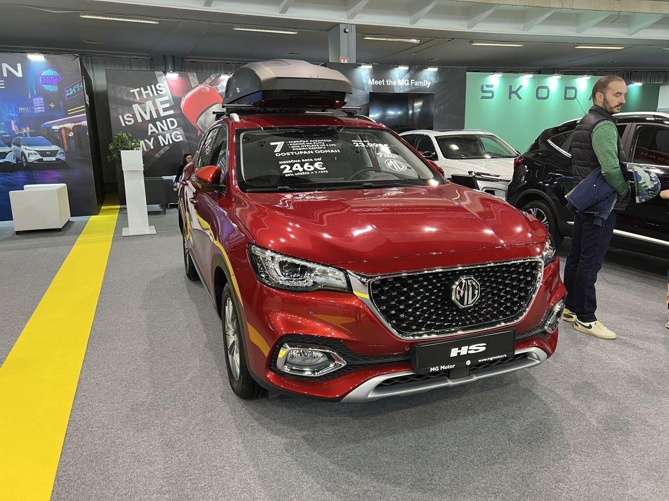 Red SUV front view with roof cargo box at indoor car show