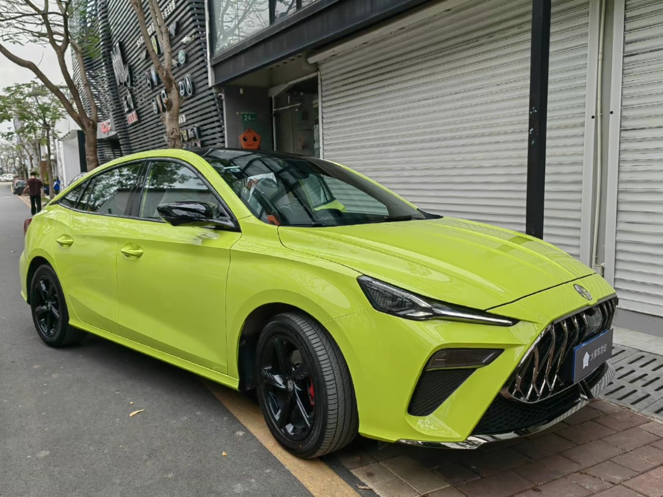Lime green electric sedan with bold grille and LED headlights