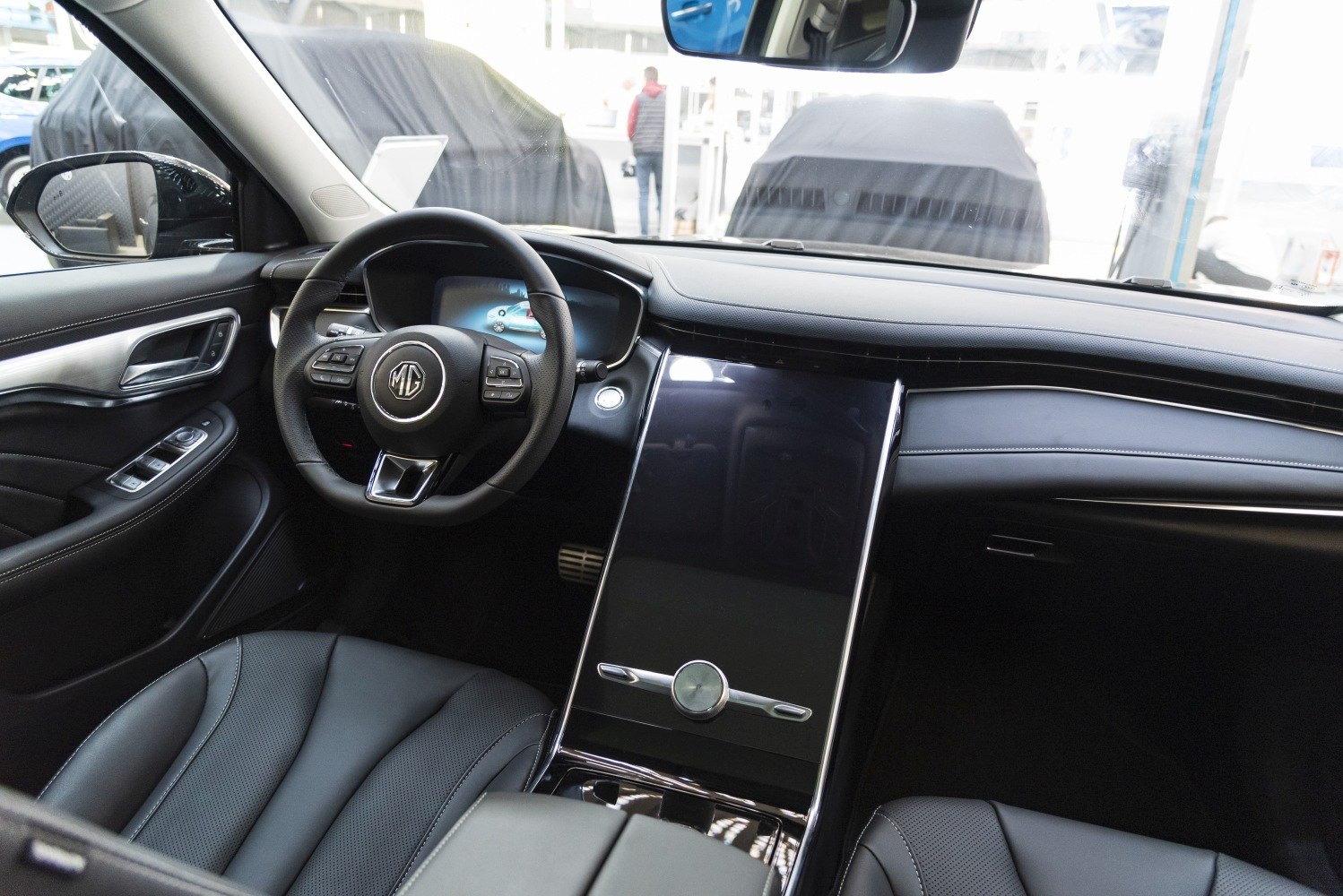 Digital dashboard, large vertical touchscreen, leather steering wheel with controls