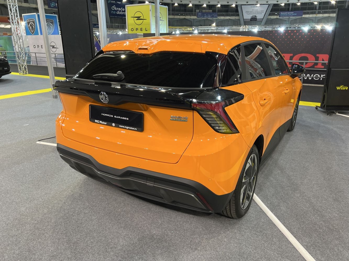 Rear view of an orange electric hatchback with angular taillights and black trim