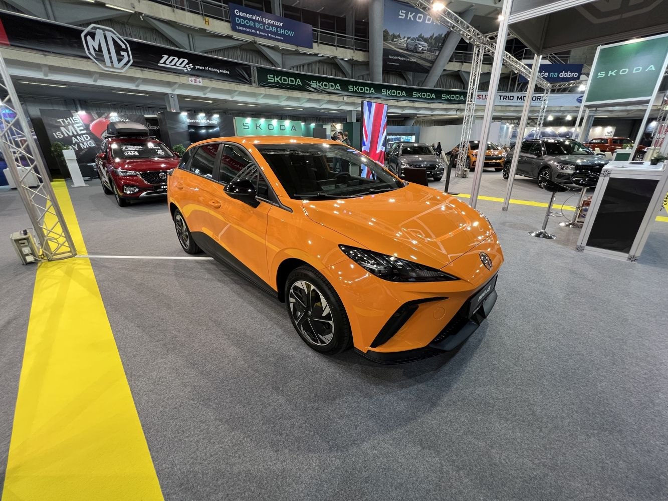 Orange compact electric hatchback with sharp headlights and aerodynamic design