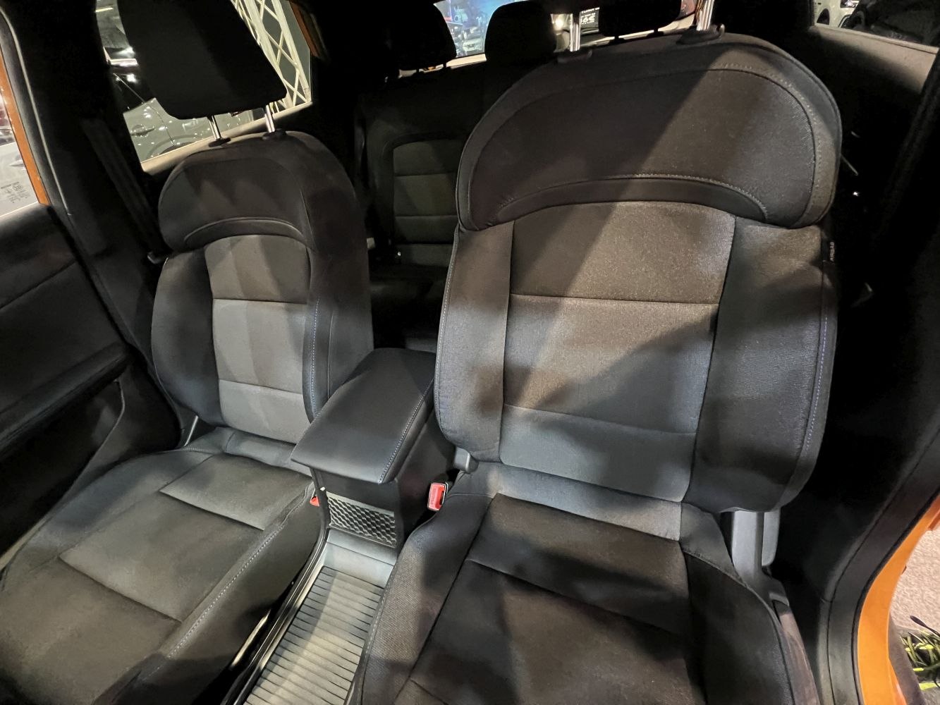 Close-up of front seats and center armrest in car interior