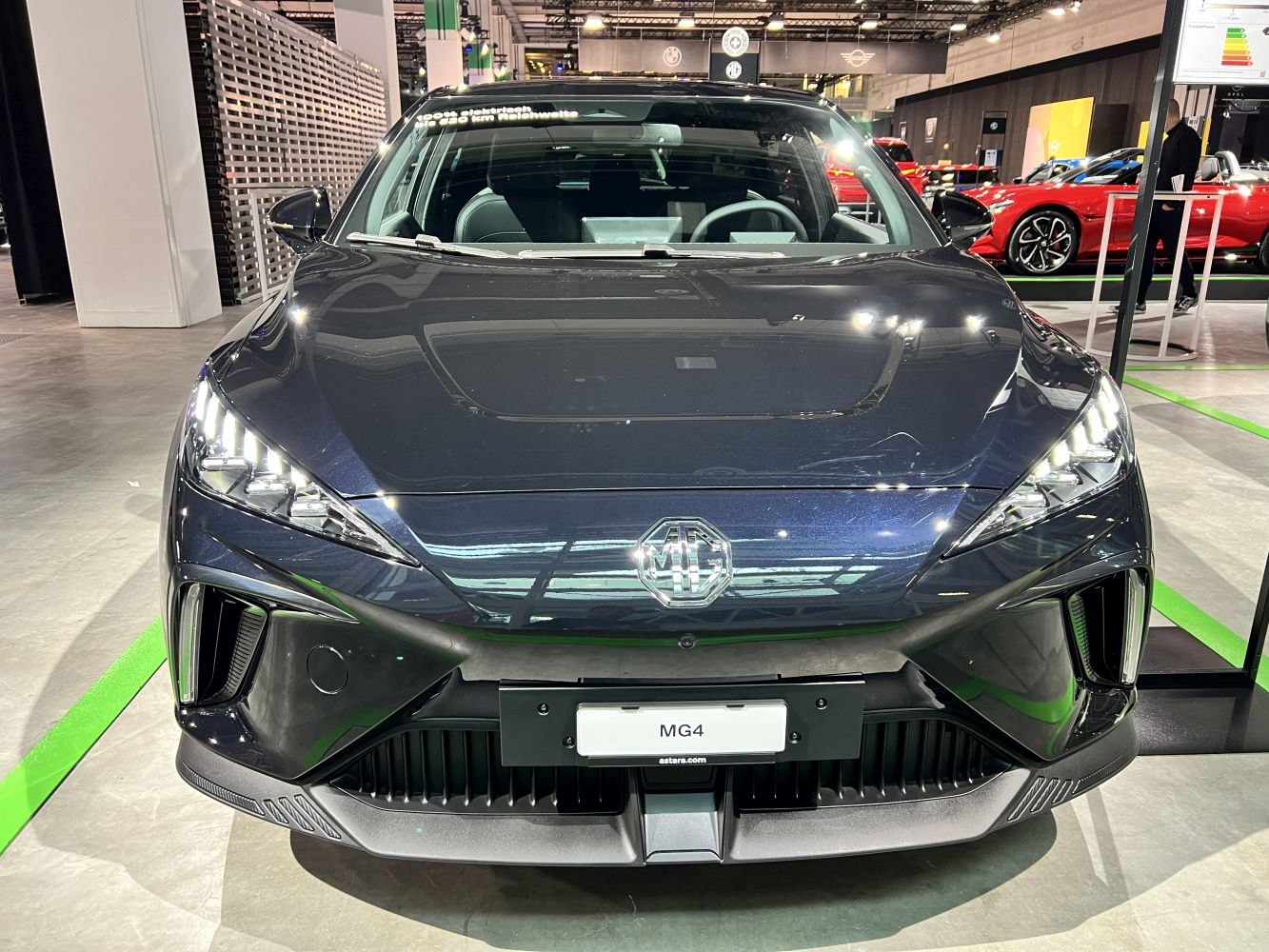 Front view of an electric hatchback with LED headlights and sleek aerodynamic hood.