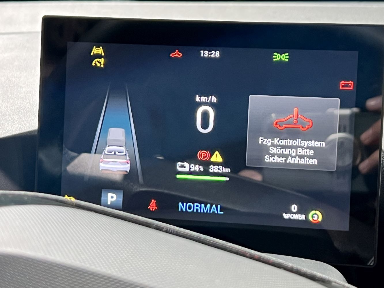 Digital dashboard with speedometer, battery status, and vehicle control system warning.