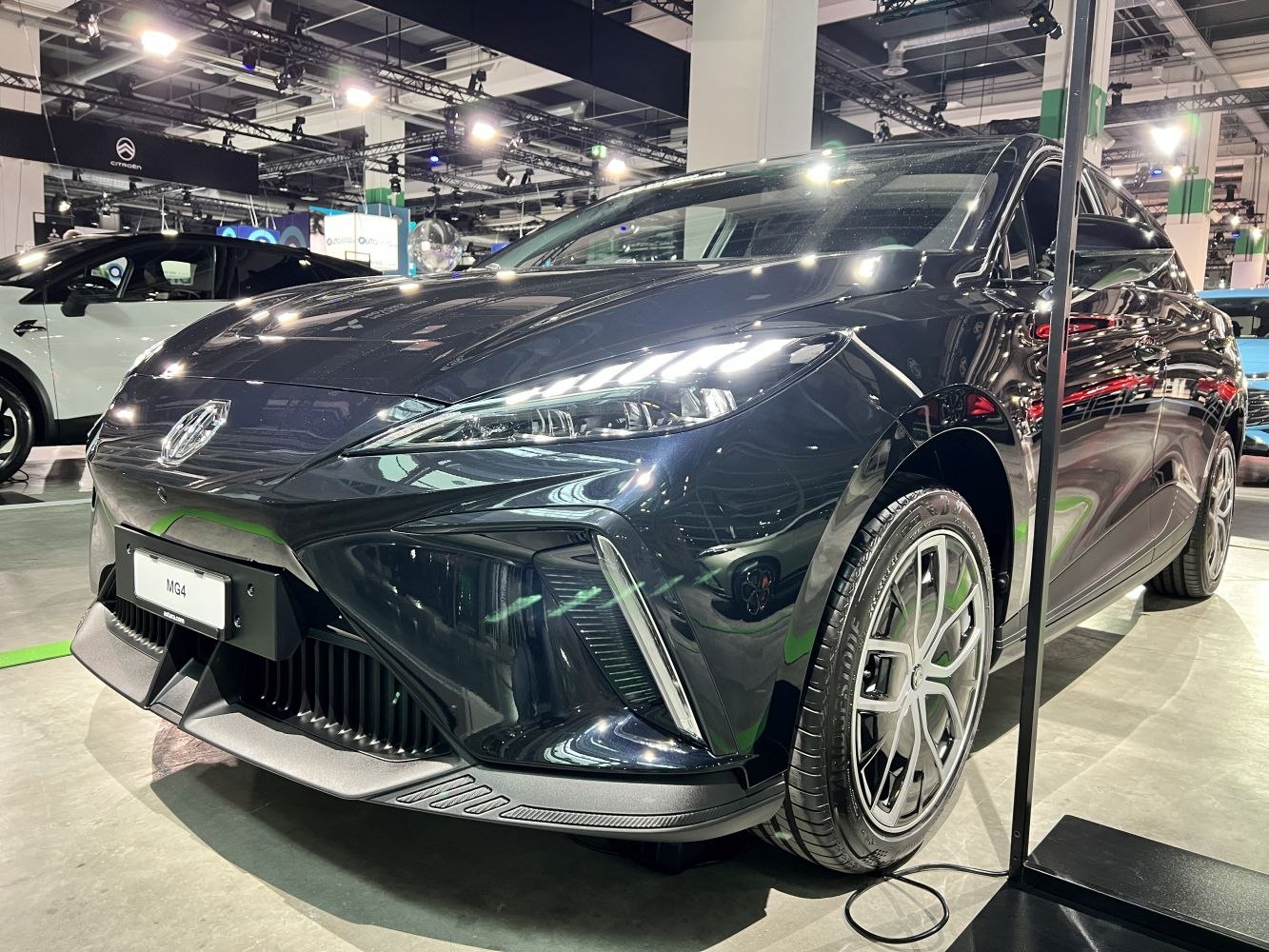 Close-up of sleek LED headlights and alloy wheels in showroom light.