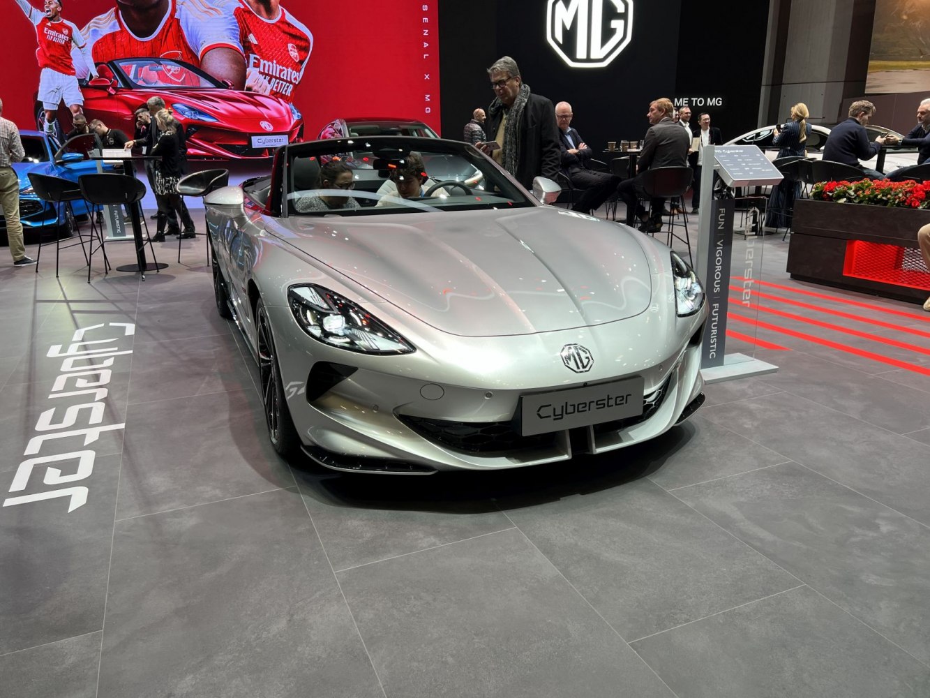Front view of silver electric convertible roadster with sleek headlights.
