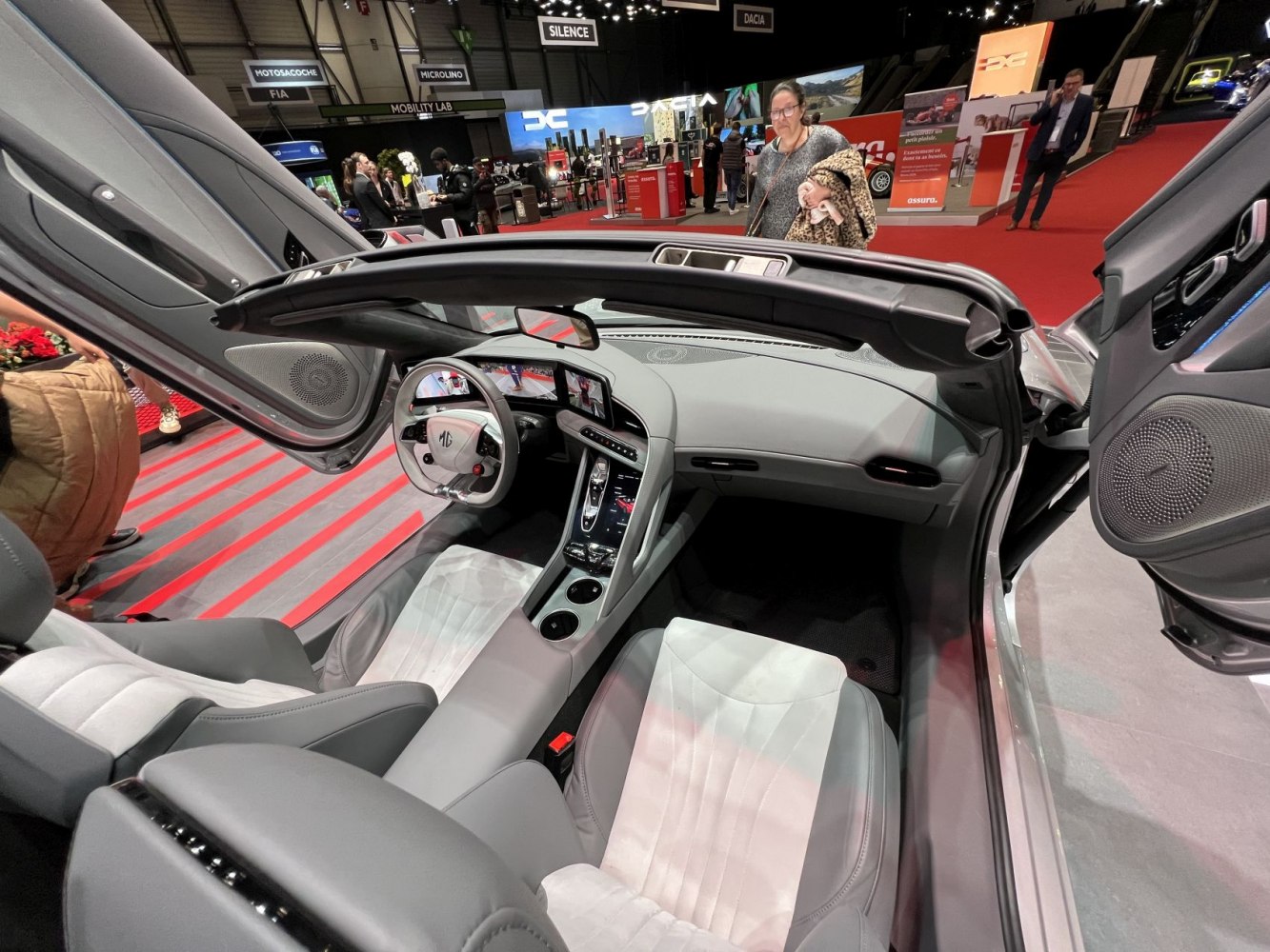 Butterfly doors open to reveal sporty seats and dual digital dashboard screens.