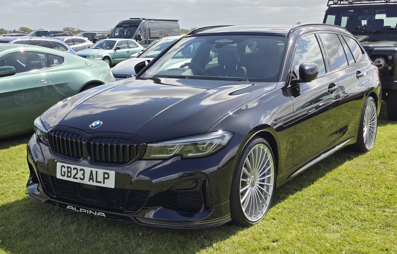 Black sports wagon with Alpina multi-spoke wheels and aggressive front grille
