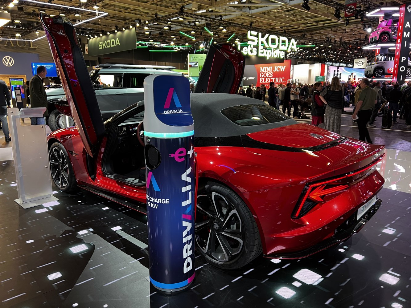 Red electric sports coupe with butterfly doors and charging station