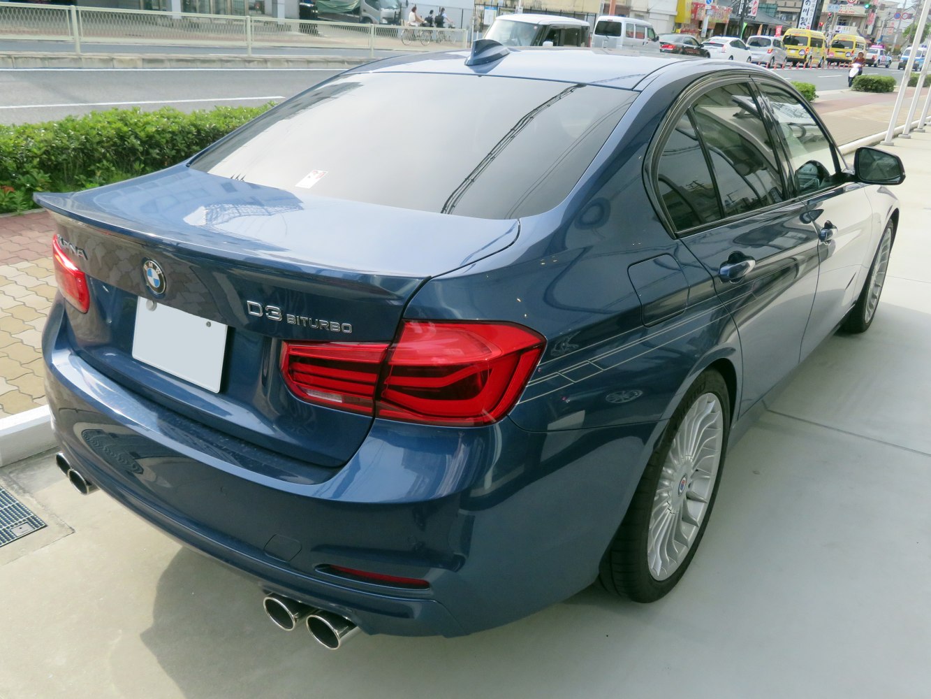 Rear view of a sedan with quad exhaust tips and distinct taillights.