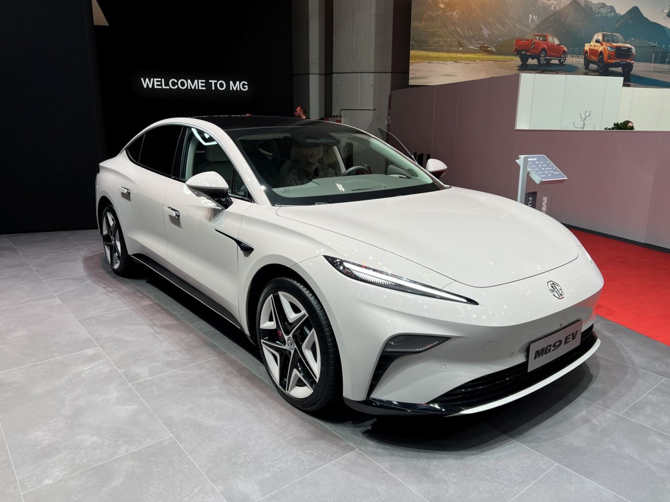 White electric sedan with sleek LED headlights and sporty alloy wheels.