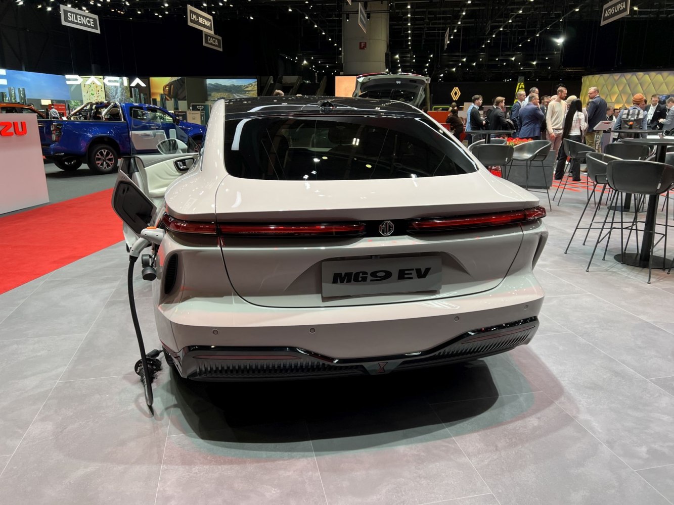 Rear view of electric sedan with open charging port and sleek horizontal taillights