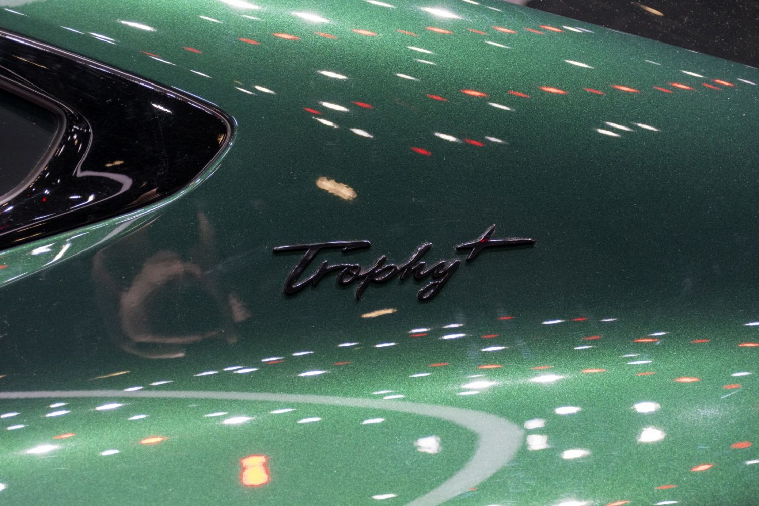 Close-up of Trophy badge on green painted car surface