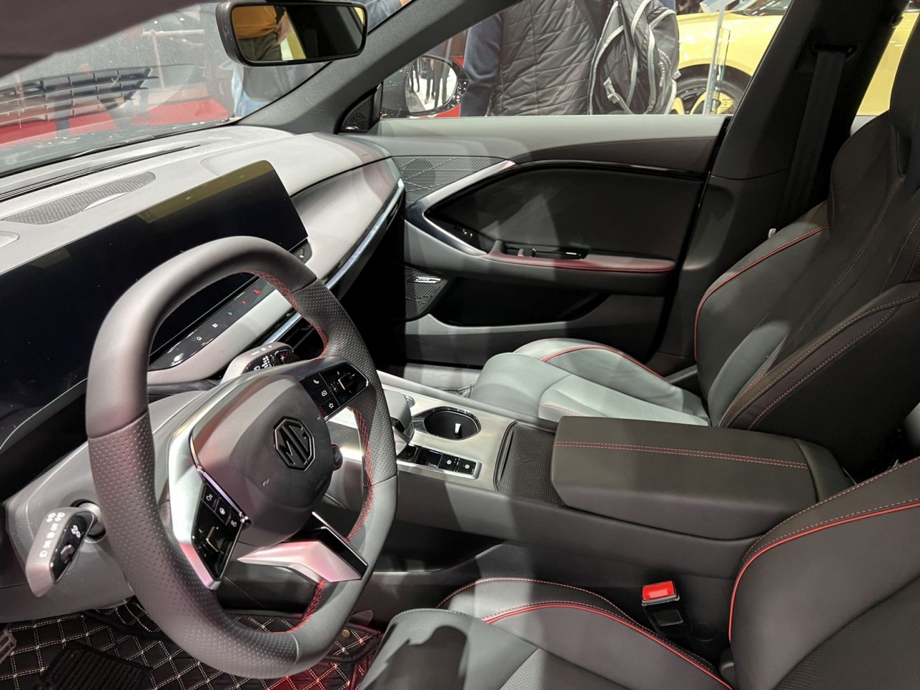 Steering wheel, dashboard, and premium seats with red stitching.