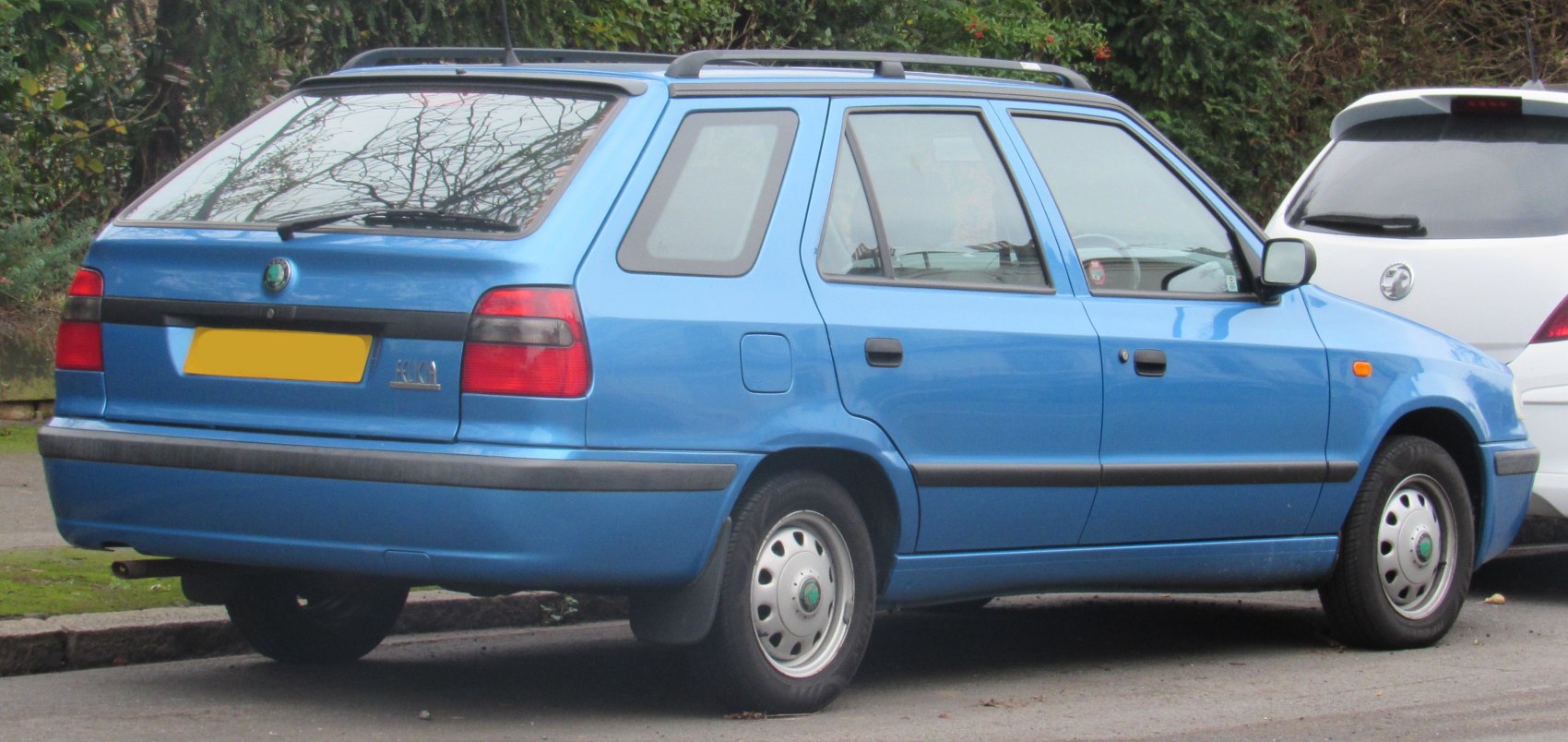 Compact blue station wagon with roof rails and rear wiper