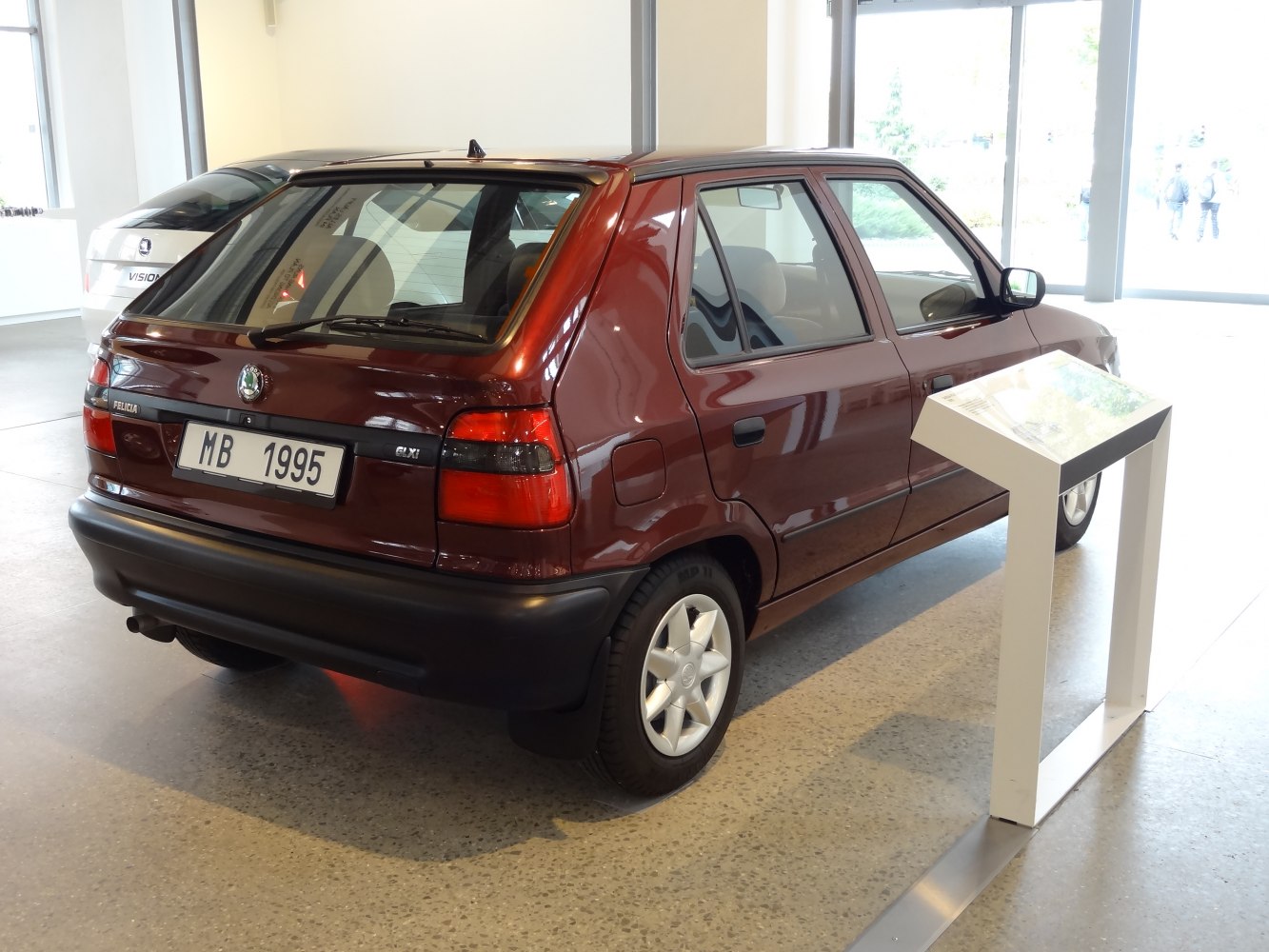 Rear-side view of a compact hatchback with distinct tail lights and black bumper.