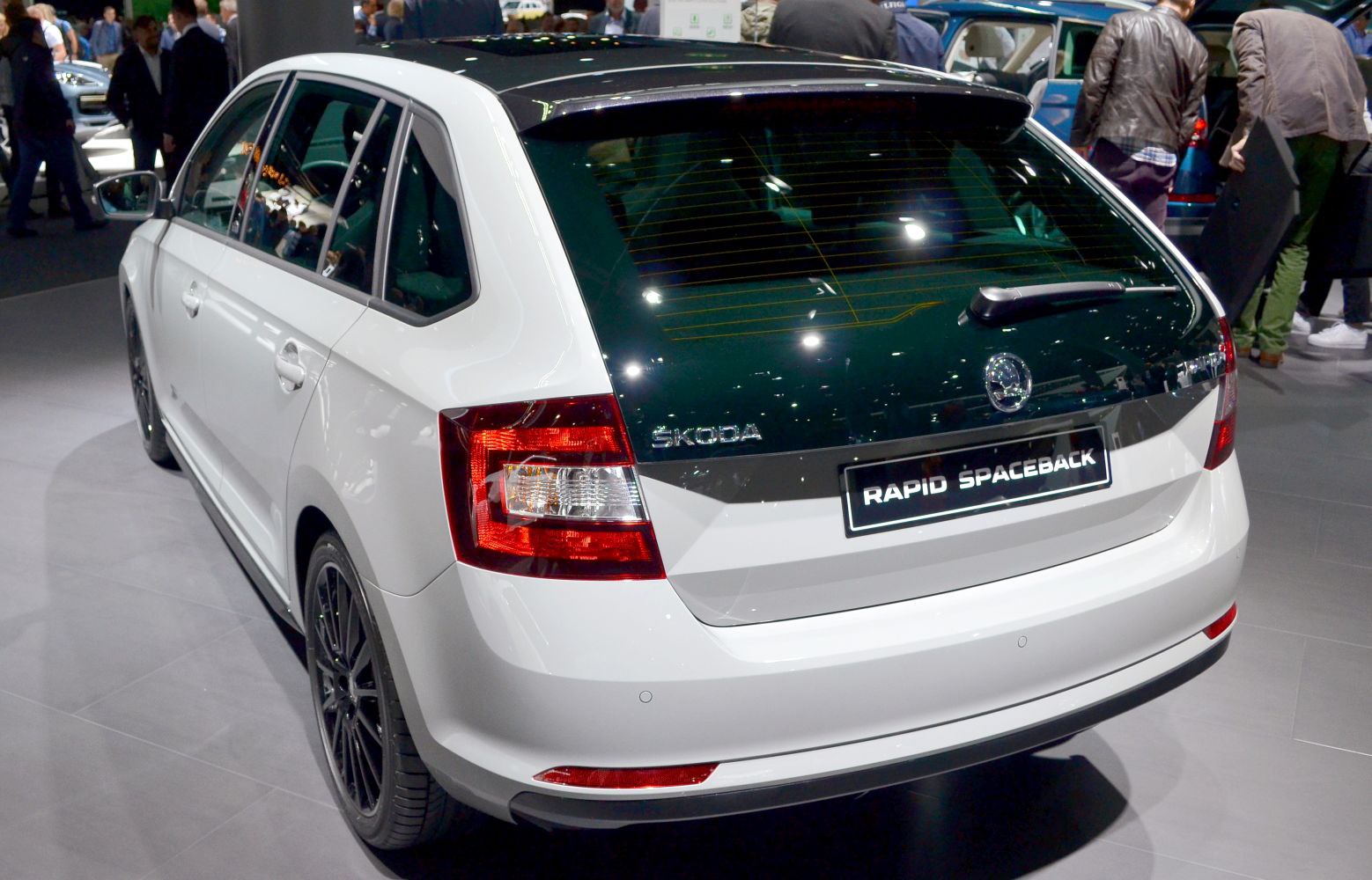 Rear and side view of hatchback with black roof and clear tail lights