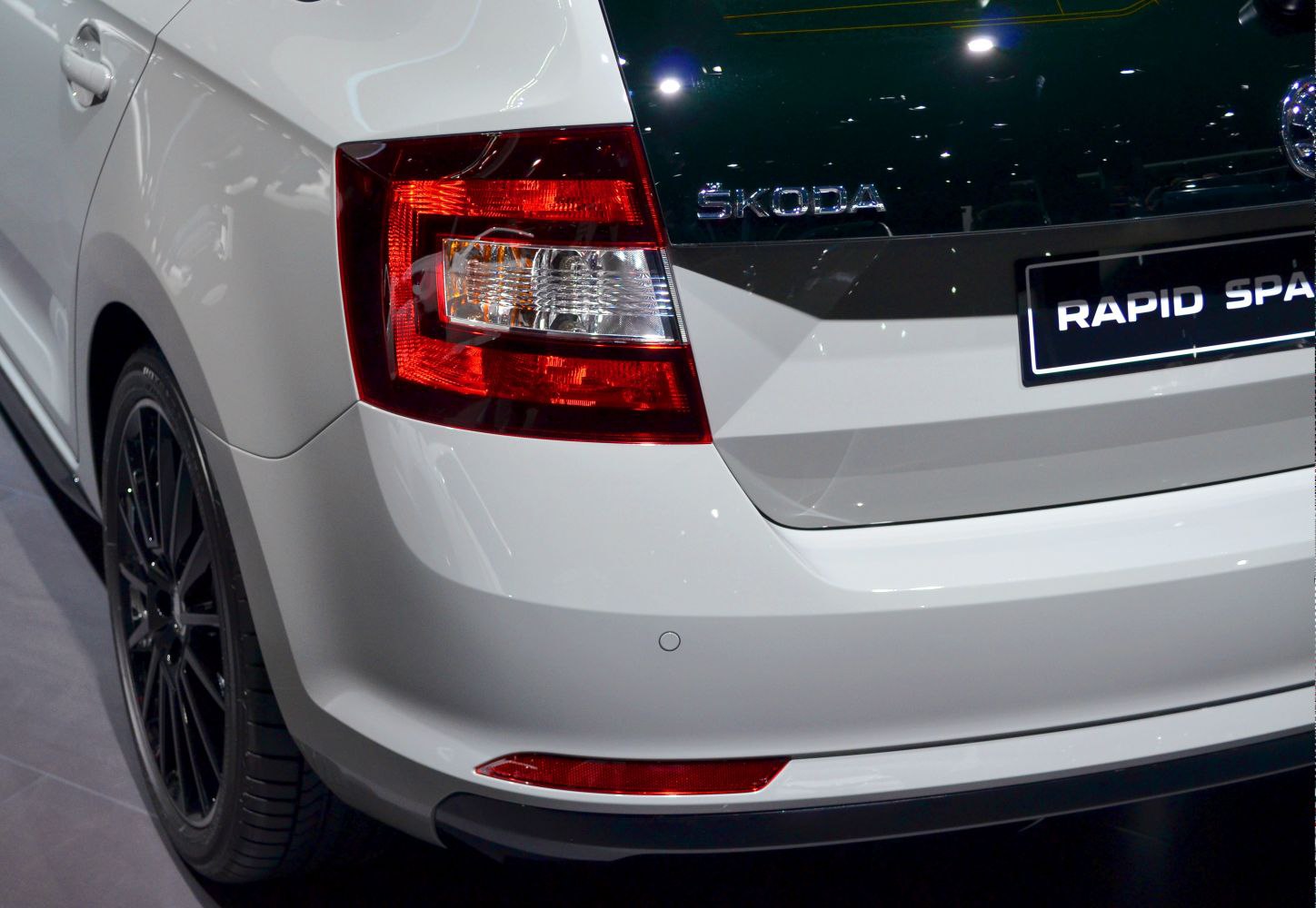 Close-up of rear light cluster and Skoda badge on white car