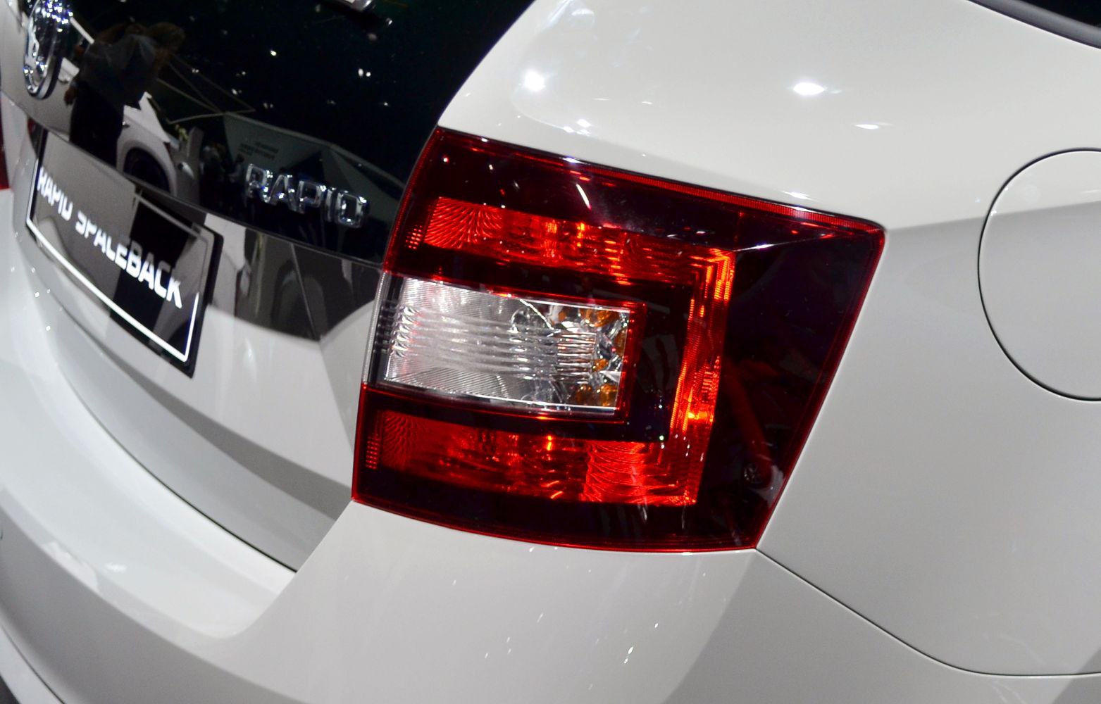 Close-up of rear taillight and badge on white vehicle rear