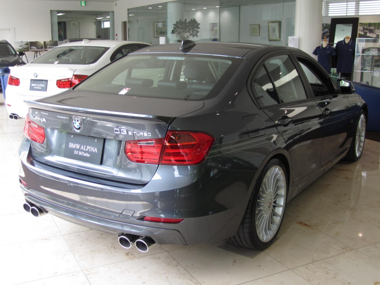 Rear view of sedan with quad exhaust and Alpina wheels