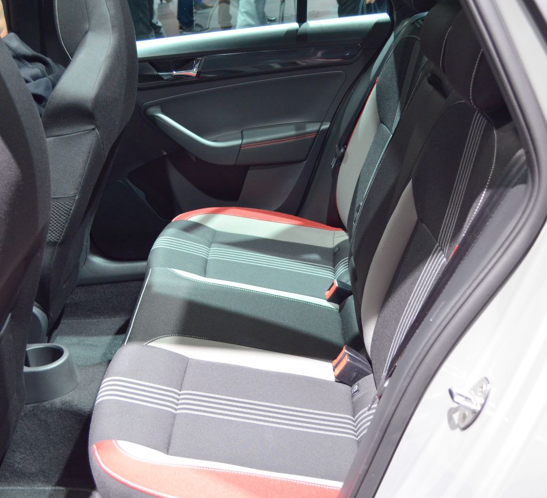 Rear passenger seat with fabric upholstery and red stitching