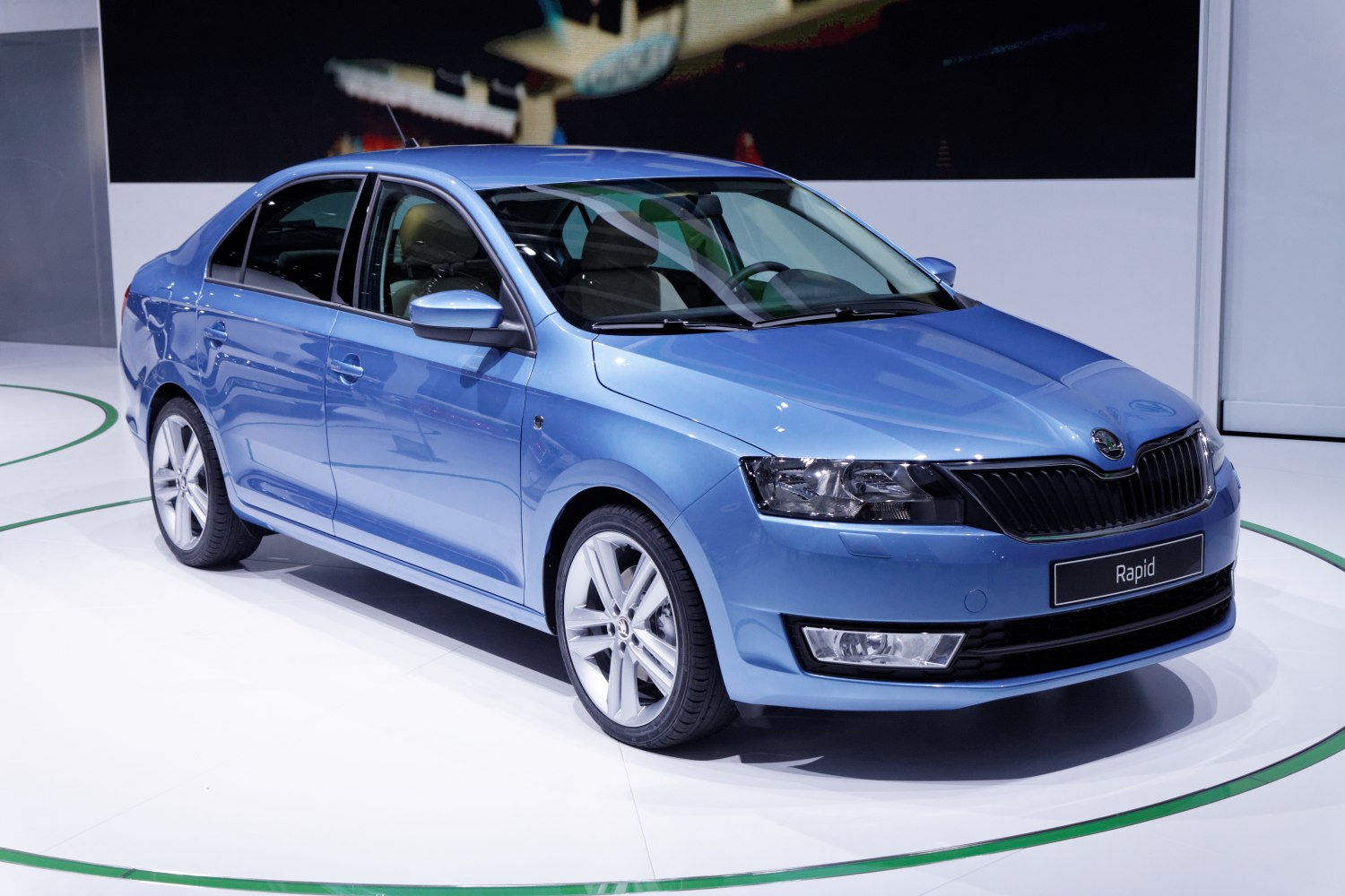 Front-side view of blue sedan with modern headlights and alloy wheels