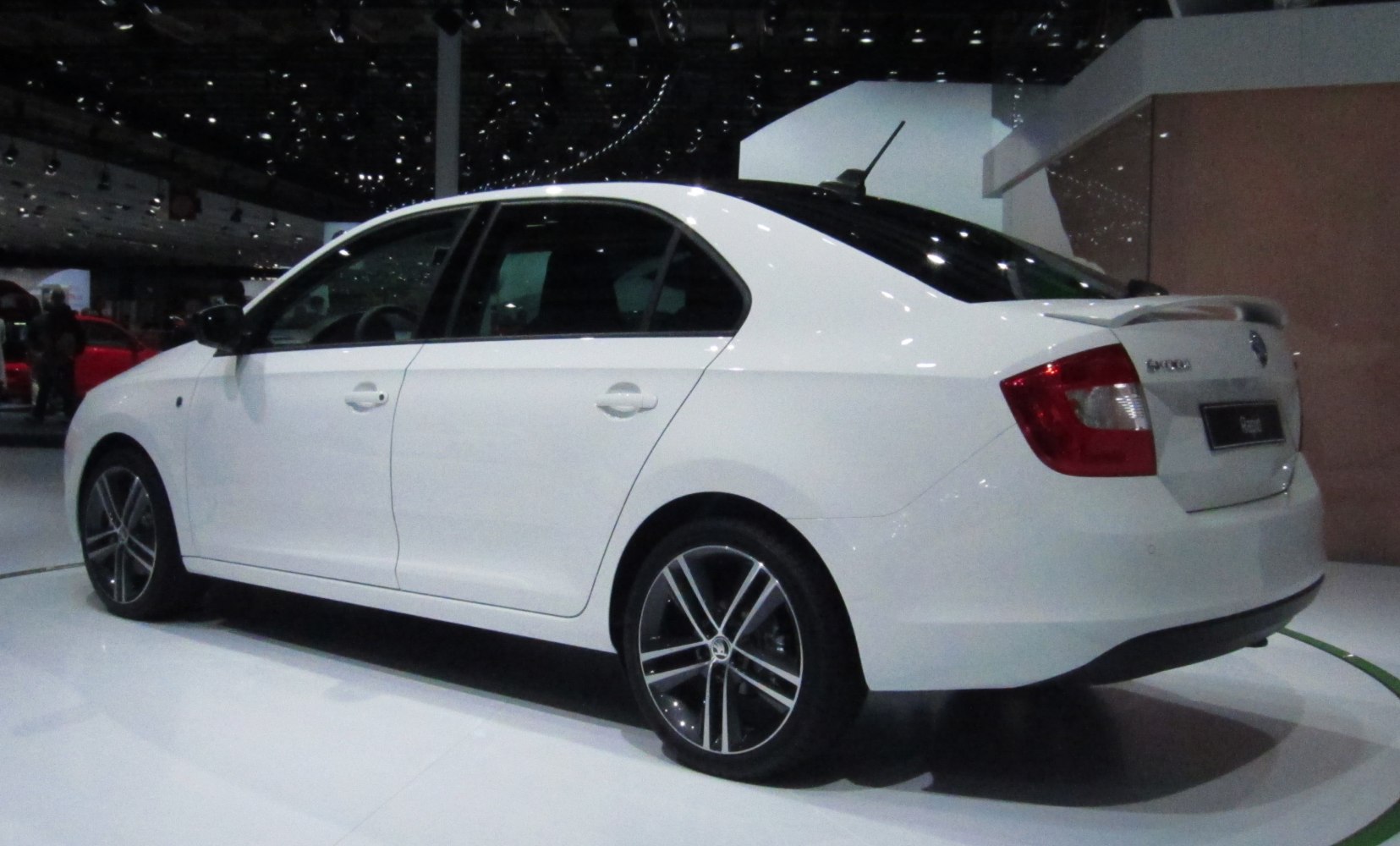 White sedan with rear spoiler and alloy wheels side view