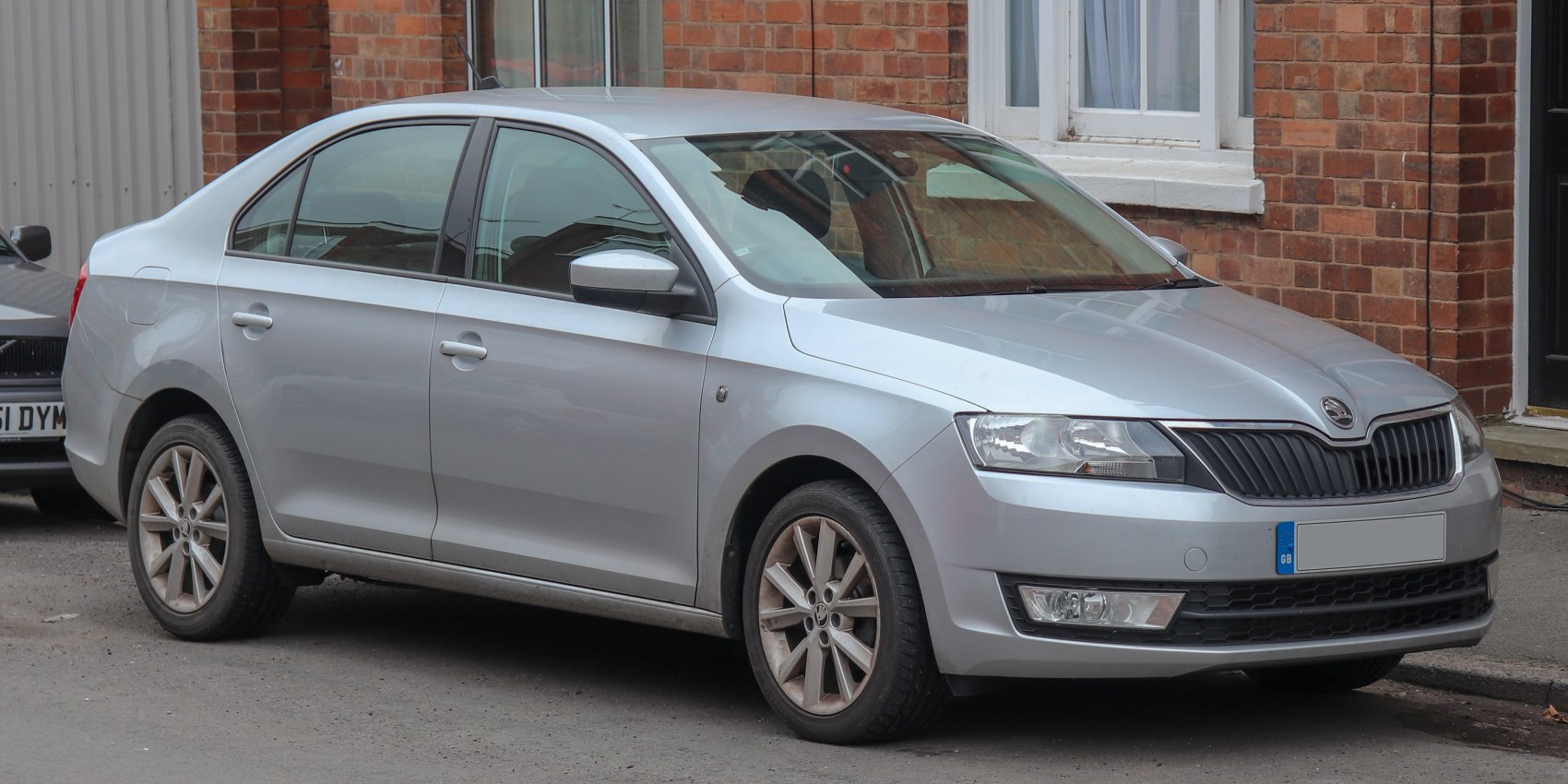 Silver sedan with distinctive front grille and alloy wheels parked in an urban setting