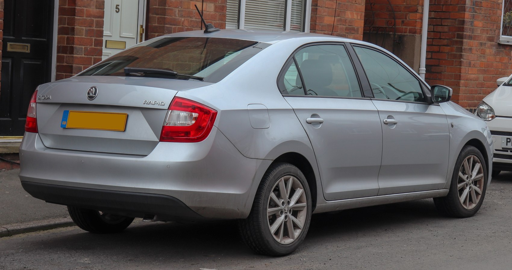 Rear and side view of sedan with alloy wheels and compact design.