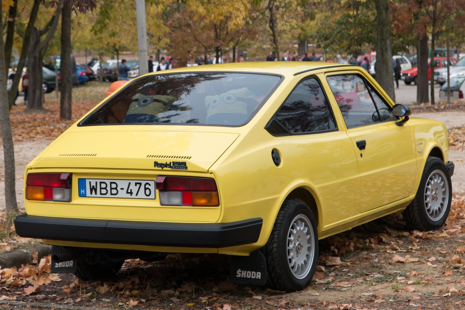 Yellow 1980s hatchback rear angle showing taillights and rear windows