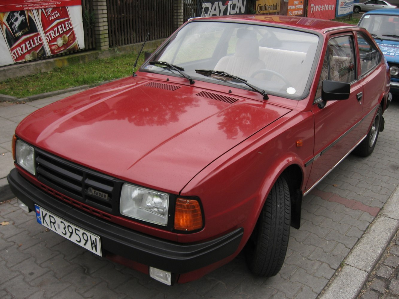 Vintage red hatchback with rectangular headlights and black grille