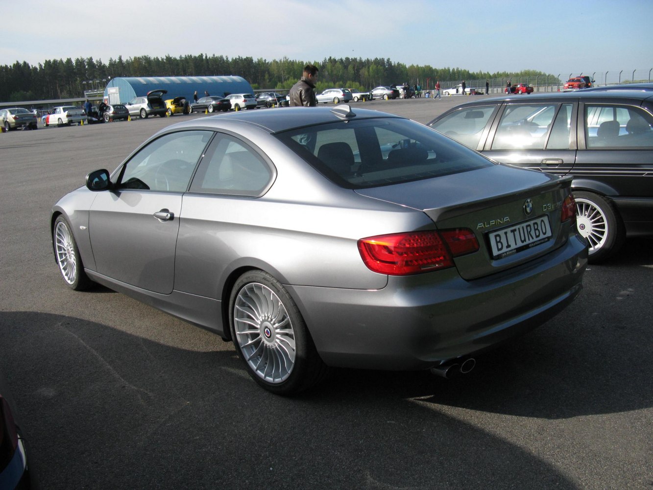 Rear three-quarter silver coupe with multi-spoke alloy wheels and dual exhaust
