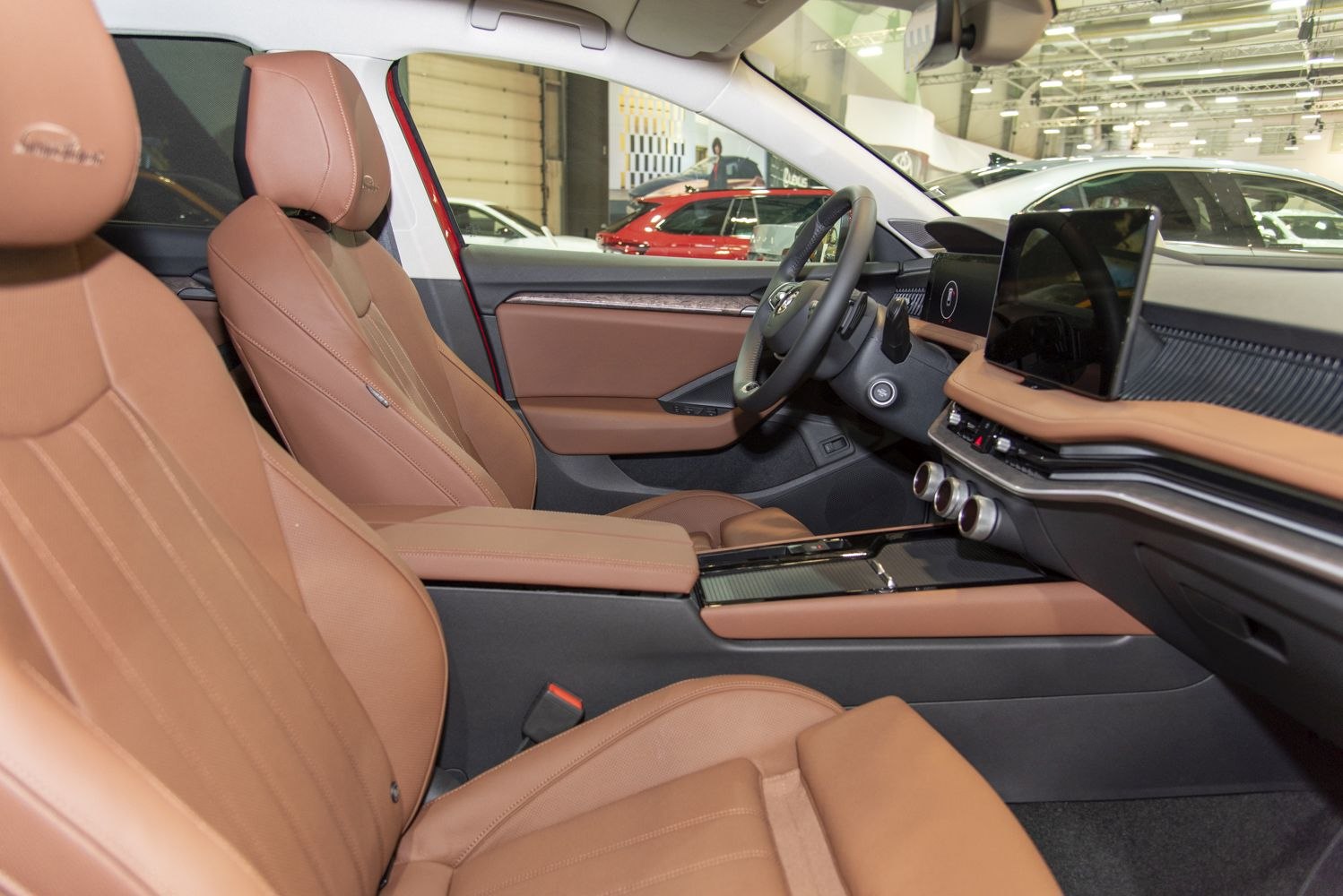 Tan leather seats with modern dashboard and infotainment screens