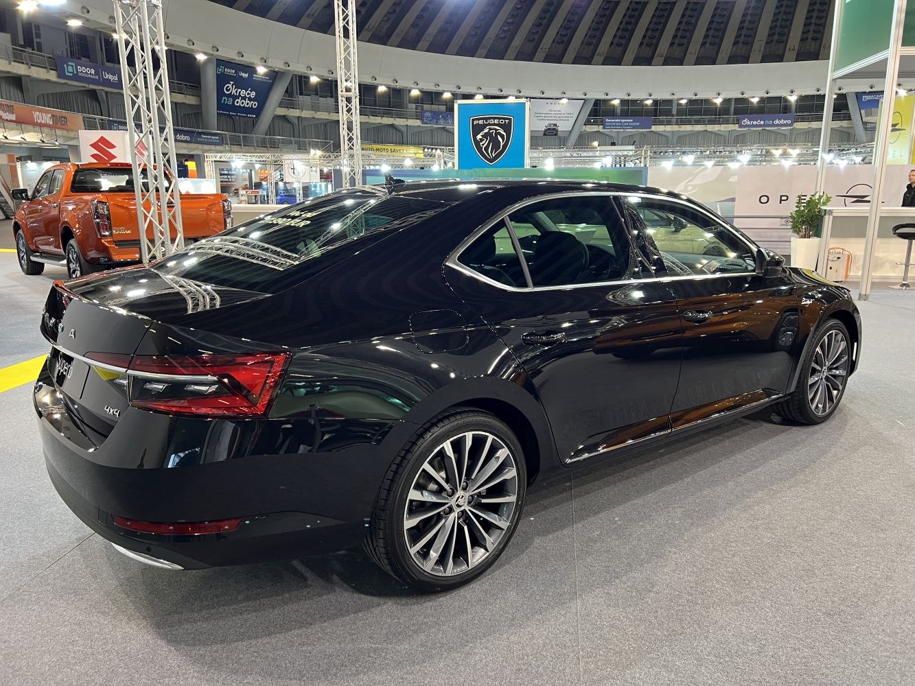 Rear view of a sleek sedan showcasing LED taillights and multi-spoke alloy wheels.