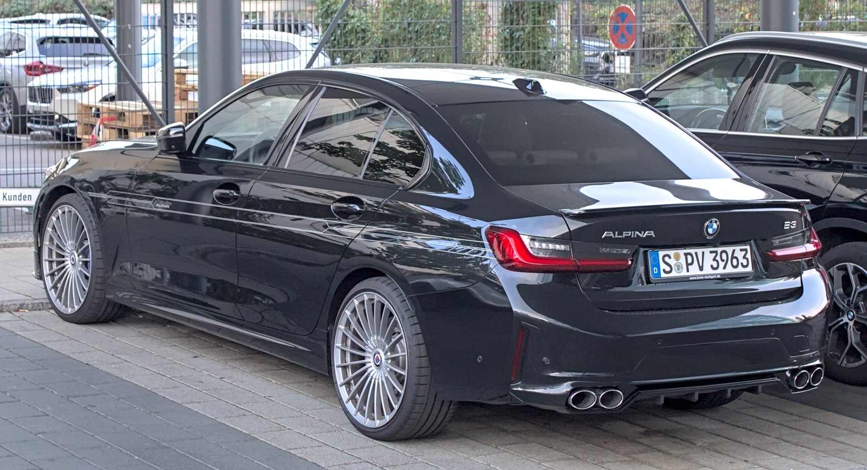 Rear side view showing quad exhausts and multi-spoke wheels