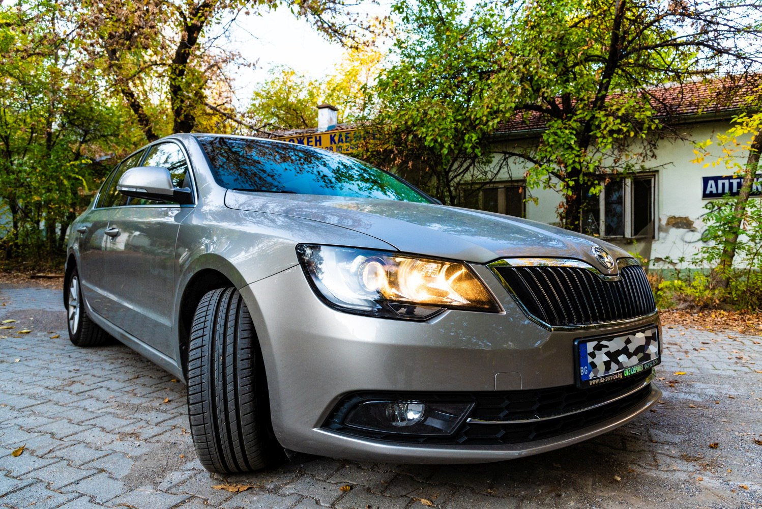 Front view of sedan with illuminated headlights and prominent grille