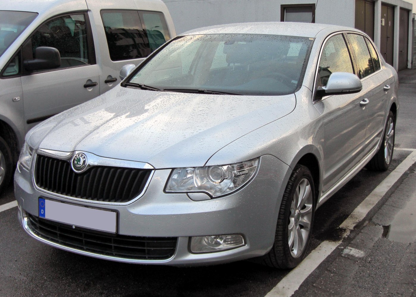 Front exterior with grille and headlights, silver sedan parked