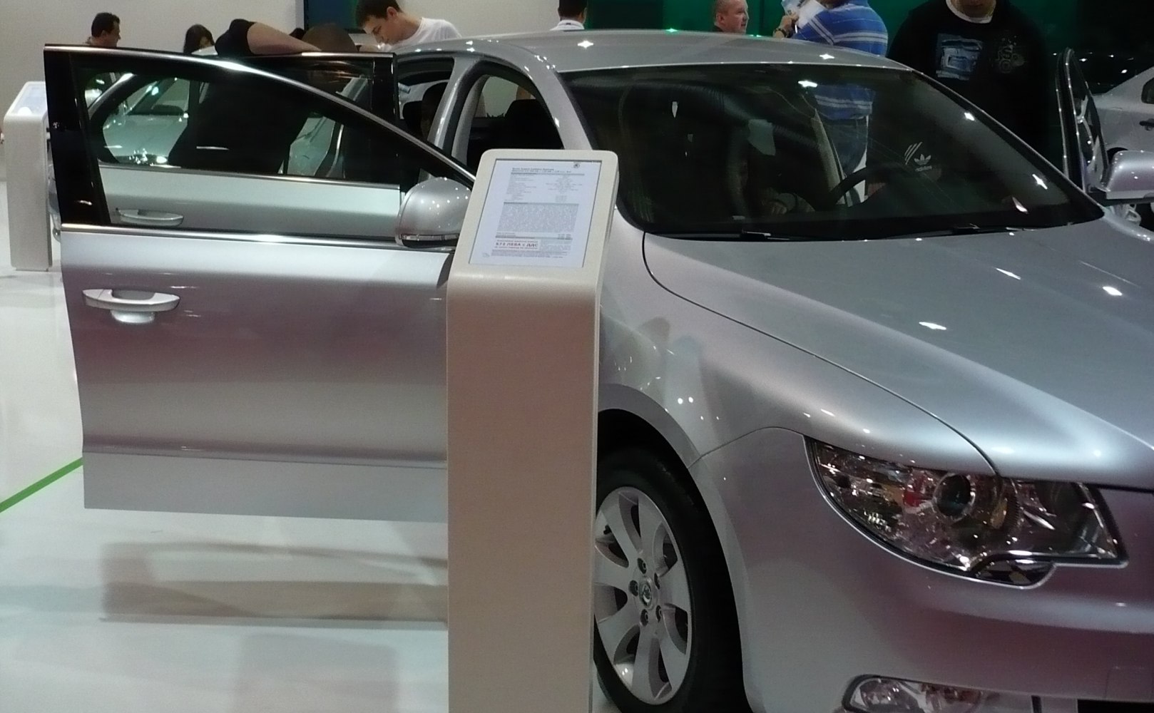 Silver mid-size sedan with open front door and clear headlight details