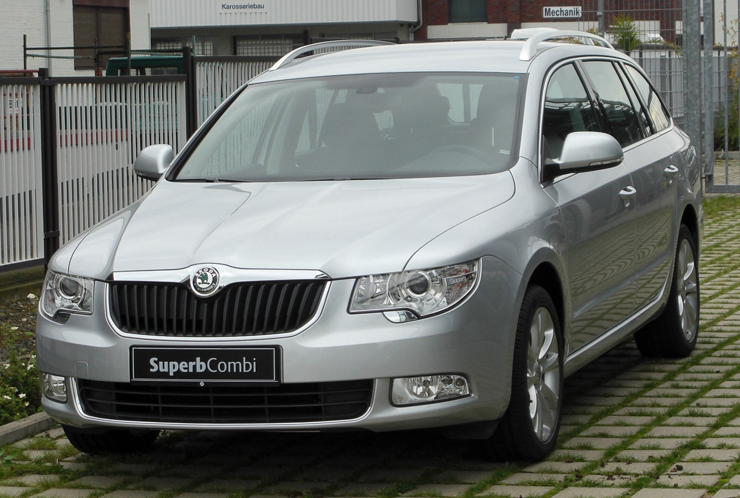 Front view with grille, headlights, and roof rails of a silver estate vehicle