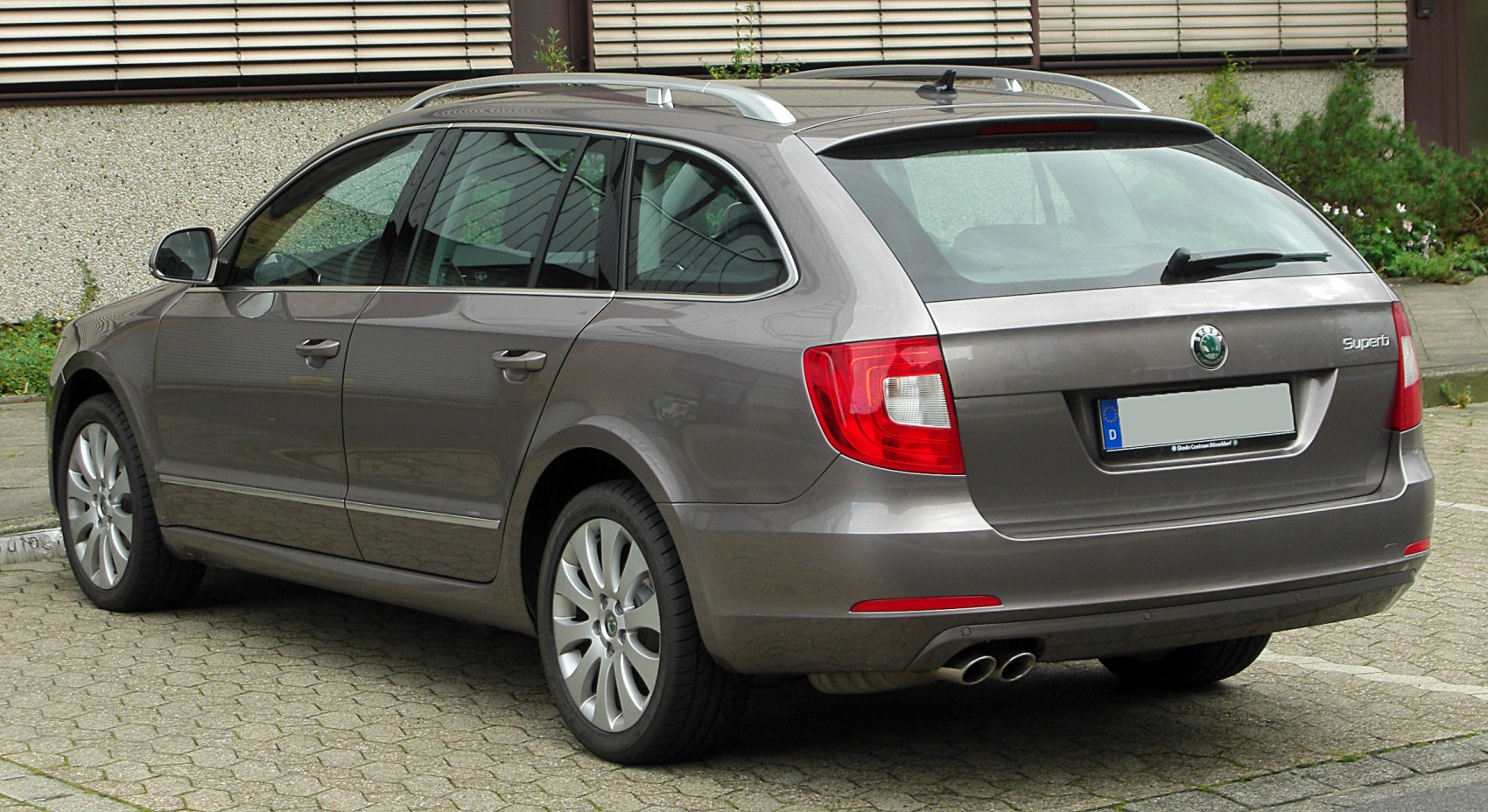 Rear side view of a station wagon with roof rails and dual exhaust