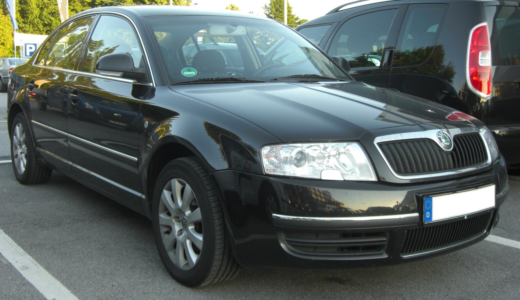 Black executive sedan with clear headlights, chrome trim, and alloy wheels.