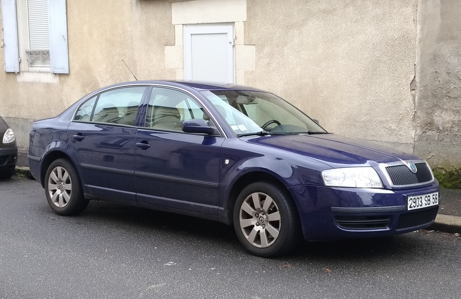 Blue sedan with alloy wheels and mid-2000s design