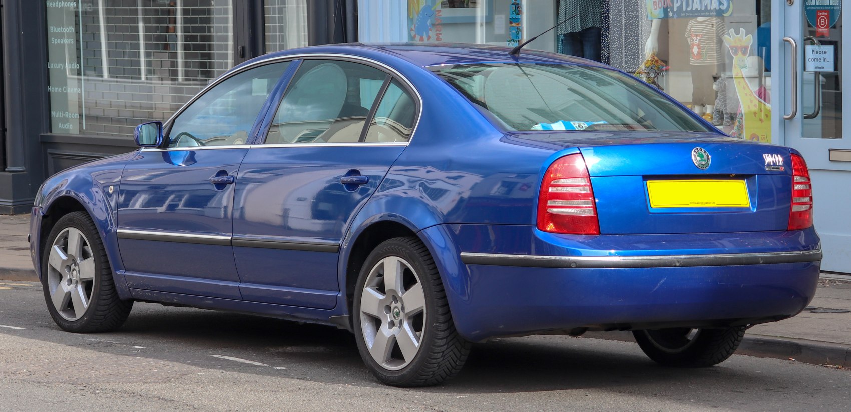 Blue sedan four-door rear side with alloy wheels and distinct taillights